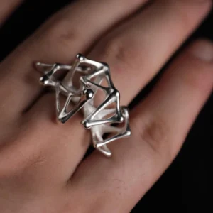 Leaping Orbit Handcrafted 999 Fine Silver Statement Ring with abstract geometric design, worn on hand; a sculptural Silver Statement Ring featuring smooth interconnected shapes, styled with dramatic lighting.
