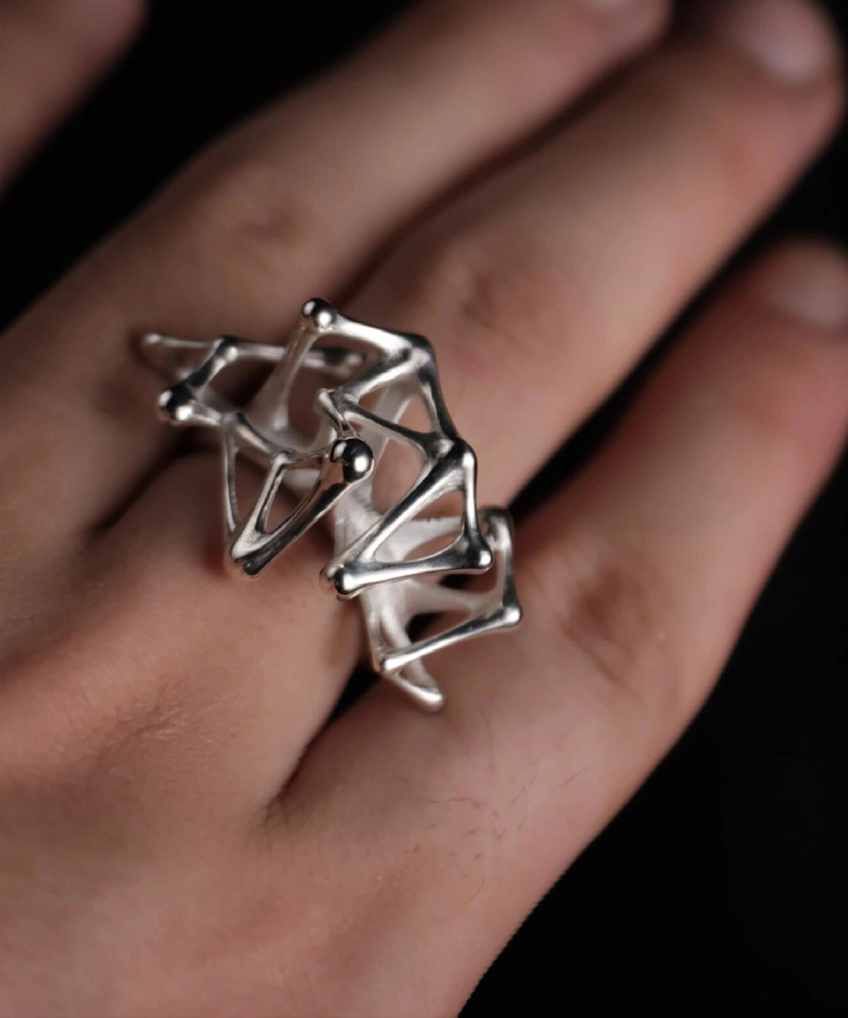 Leaping Orbit Handcrafted 999 Fine Silver Statement Ring with abstract geometric design, worn on hand; a sculptural Silver Statement Ring featuring smooth interconnected shapes, styled with dramatic lighting.