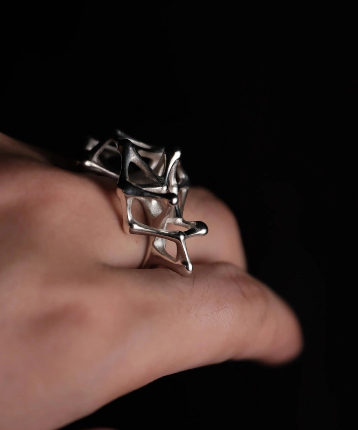 Leaping Orbit Handcrafted 999 Fine Silver Statement Ring with abstract geometric hollow design, worn on hand; a sculptural Silver Statement Ring featuring polished interconnected shapes, styled against a dark background.
