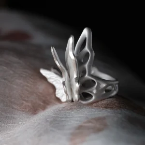 Close-up of a sculptural S925 Sterling Silver Butterfly Ring worn on a finger, featuring lattice-style wings and modern matte finish; elegant Silver Ring design blending organic and geometric elements in a handcrafted Butterfly Ring.