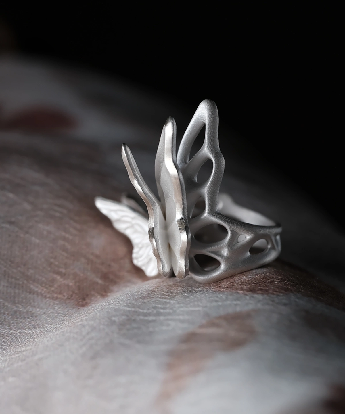 Close-up of a sculptural S925 Sterling Silver Butterfly Ring worn on a finger, featuring lattice-style wings and modern matte finish; elegant Silver Ring design blending organic and geometric elements in a handcrafted Butterfly Ring.