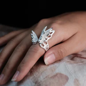 Close-up of a hand wearing a S925 Sterling Silver Butterfly Ring with sculptural open wings and lifelike texture, set against a dark background; elegant Silver Ring showcasing handcrafted Butterfly Ring artistry and nature-inspired design.