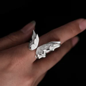 Close-up of a hand wearing a S925 Sterling Silver Butterfly Ring with sculptural open wings and lifelike texture, set against a dark background; elegant Silver Ring showcasing handcrafted Butterfly Ring artistry and nature-inspired design.