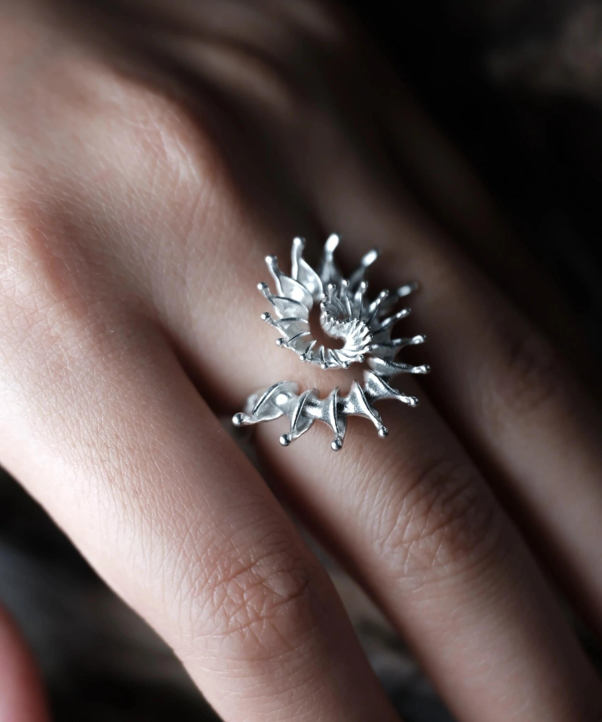 S925 Sterling Silver Spiral Ring Jewelry-Handmade Artistic Statement Ring 05 Close-up of a hand wearing a S925 Sterling Silver Spiral Ring Jewelry with radiating petal-like extensions in a stylized sunburst design; bold Statement Ring showcasing intricate craftsmanship and sculptural Silver Ring elegance.