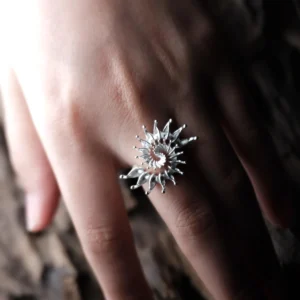 S925 Sterling Silver Spiral Ring Jewelry-Handmade Artistic Statement Ring 07 Close-up of a hand wearing a S925 Sterling Silver Spiral Ring Jewelry with radiating petal-like spikes in a sunburst design, set against a natural textured background; bold Statement Ring showcasing artistic craftsmanship and sculptural Silver Ring elegance.