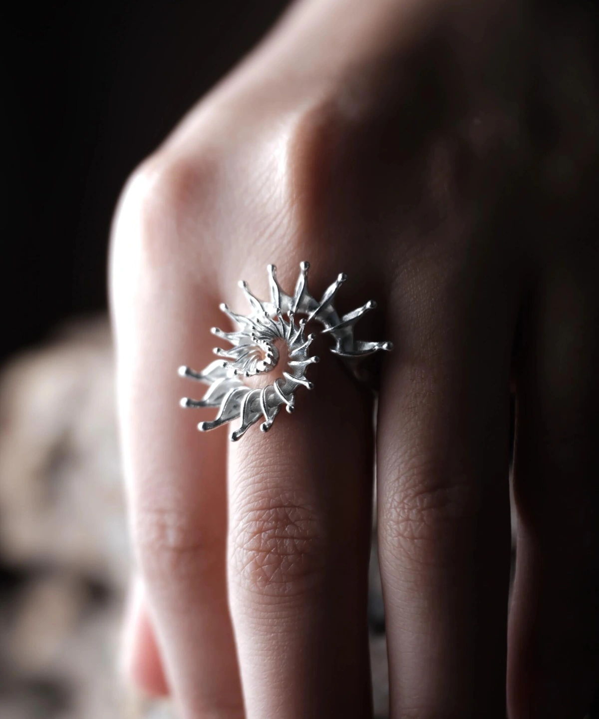 S925 Sterling Silver Spiral Ring Jewelry-Handmade Artistic Statement Ring 08 Close-up of a hand wearing a S925 Sterling Silver Spiral Ring Jewelry with radiating sculptural design, resembling a sunburst or nautilus shell; bold Statement Ring showcasing artistic craftsmanship and elegant Silver Ring texture.