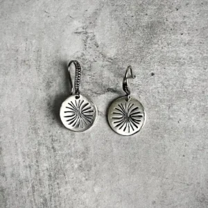 Disc Earrings in S925 Sterling Silver with engraved sunburst design; placed on textured gray surface to highlight handcrafted detail, minimalist elegance, and the radiant etching of engraved earrings.