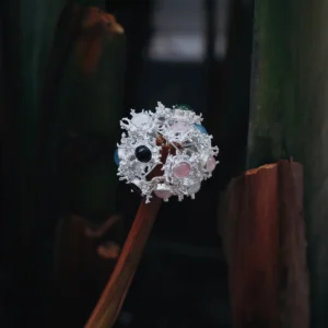 Gemstone Stud Earrings in S925 Sterling Silver with organic splash-inspired design and multicolored stones; decorative piece mounted on dried stem, styled against moody natural background to highlight contrast and craftsmanship.