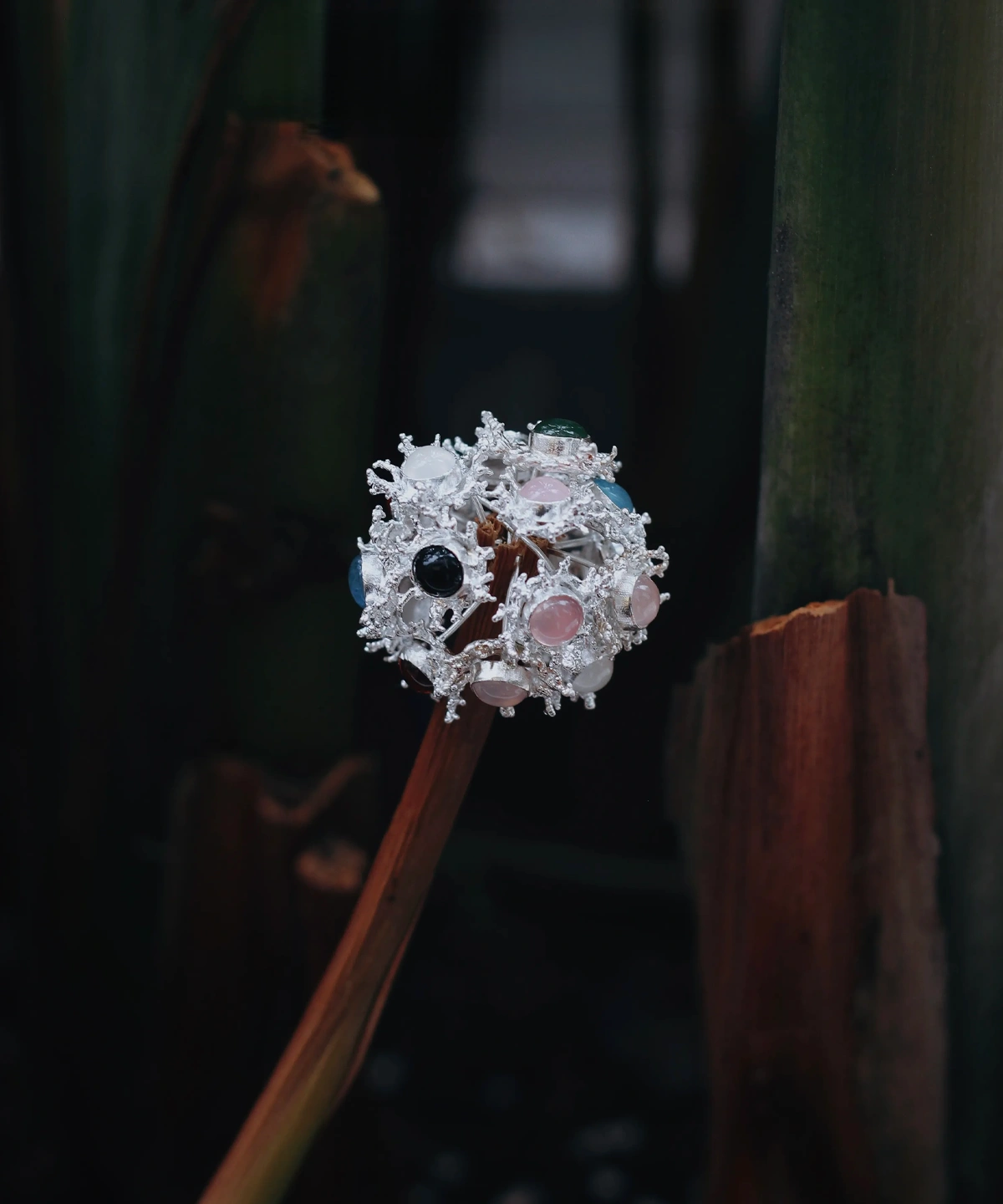 Gemstone Stud Earrings in S925 Sterling Silver with organic splash-inspired design and multicolored stones; decorative piece mounted on dried stem, styled against moody natural background to highlight contrast and craftsmanship.