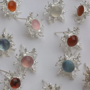 Gemstone Stud Earrings in S925 Sterling Silver with organic splash-inspired silverwork and smooth cabochon-cut stones in pink, blue, red, orange, and white; arranged on flat surface to showcase artisanal variety and vibrant elegance.