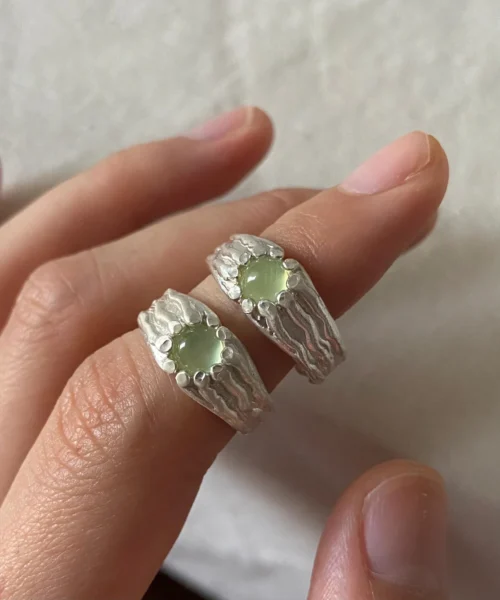 Silver Gemstone Rings with round pale green prehnite set in textured 999 silver bands, worn on adjacent fingers.