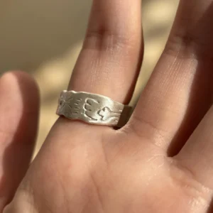 Natural Prehnite Ring in 999 Silver Green Apple Design 12 A handcrafted 999 silver ring engraved with a sunburst, paw print, and bone motif, worn on the hand against a soft background, styled to complement the Natural Prehnite Ring aesthetic.