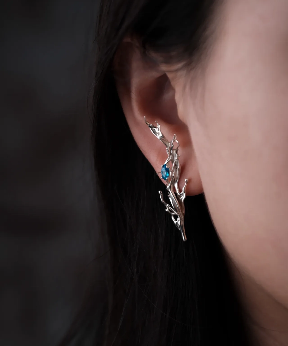 Tidewake Silver Earrings with fish-inspired design and blue gemstone; worn on ear, featuring organic branch-like structure that evokes aquatic motion and handcrafted elegance. A poetic take on nature-themed Fish Earrings.