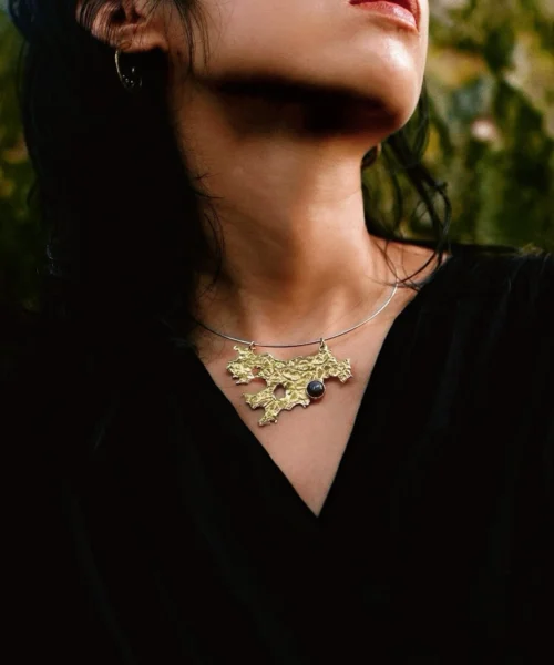 Tree Lichen Pendant on a silver choker necklace with natural agate; gold-toned organic pendant with embedded stone, worn over black fabric to highlight forest-inspired craftsmanship and poetic botanical elegance.