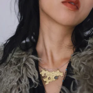 Tree Lichen Pendant on a silver choker necklace with natural agate; worn with textured outerwear, featuring gold-toned organic pendant with embedded stone, highlighting forest-inspired craftsmanship and poetic elegance.