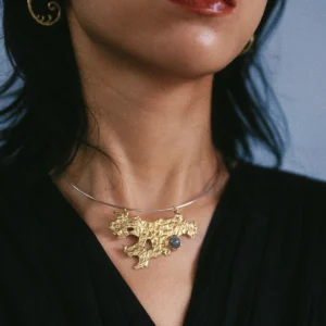 Tree Lichen Pendant on a silver choker necklace with natural agate; worn over black fabric, featuring gold-toned organic pendant with embedded stone and spiral earring, highlighting forest-inspired elegance and handcrafted detail.