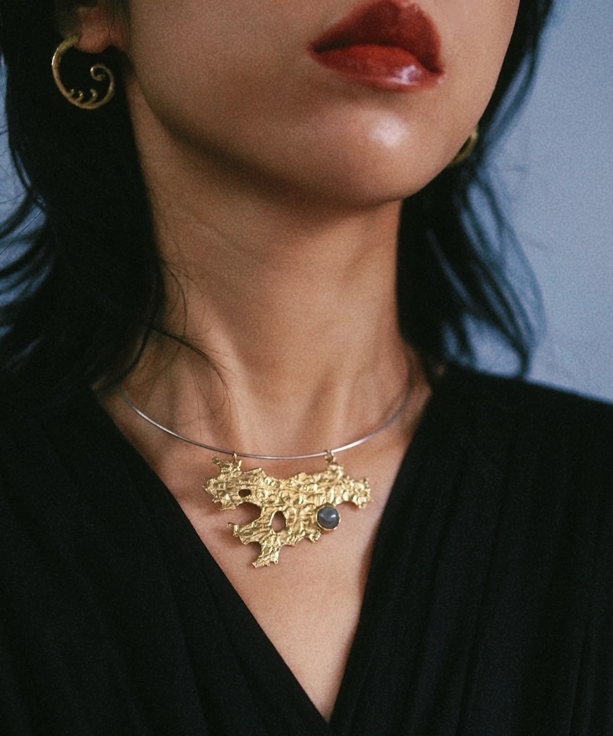 Tree Lichen Pendant on a silver choker necklace with natural agate; worn over black fabric, featuring gold-toned organic pendant with embedded stone and spiral earring, highlighting forest-inspired elegance and handcrafted detail.