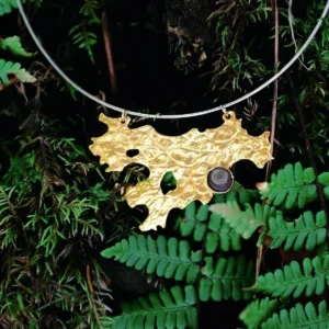 Tree Lichen Pendant on a silver choker necklace with natural agate; gold-toned organic pendant with embedded stone, styled against moss and fern backdrop to highlight forest-inspired craftsmanship and botanical elegance.