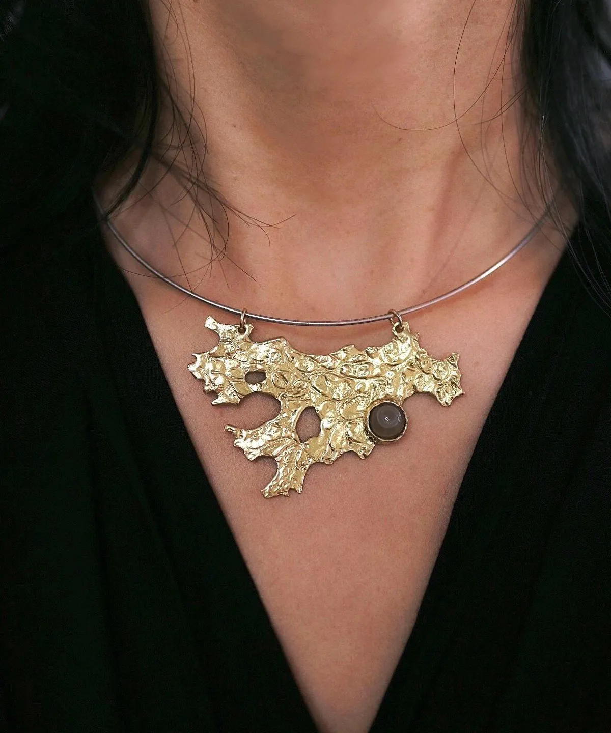 Tree Lichen Pendant on a silver choker necklace with natural agate; worn over black fabric to highlight the gold-toned organic pendant with embedded stone, showcasing forest-inspired elegance and handcrafted detail.