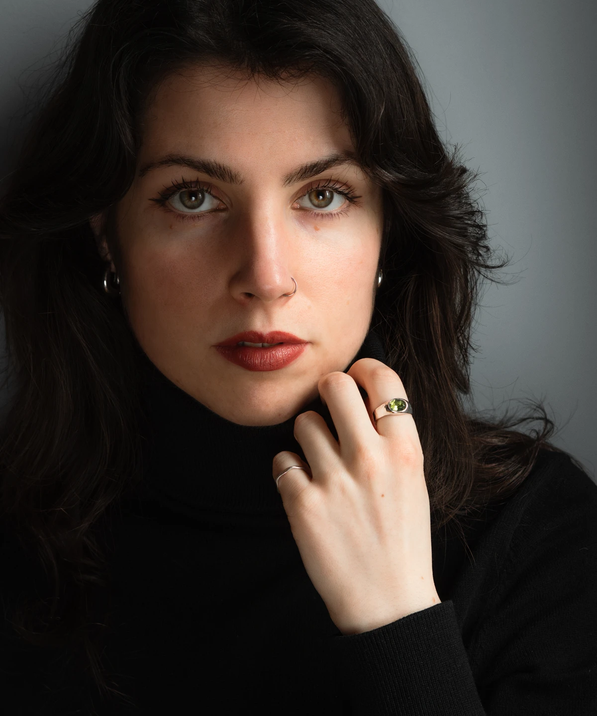 August Birthstone Ring-Natural Peridot Ring in Sterling Silver 08 Hand wearing a silver August Birthstone Ring with a green gemstone, shown against green foliage and a dark background to highlight the Natural Peridot Ring design.