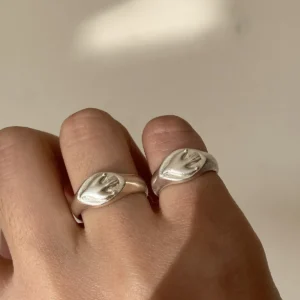 Flying Bird Ring-Handmade 999 Silver Signet Pinky Ring 14 Hand wearing two silver Signet Pinky Rings with identical raised hand motifs, shown against soft natural lighting that highlights the rings’ polished finish.