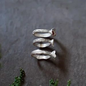 Poppy-Inspired Ruby Ring in S925 Sterling Silver 10 Three handcrafted silver rings displayed vertically on a dark textured surface, including a Poppy‑Inspired Ruby Ring with a red gemstone, styled to support SEO for a Ruby Ring product.