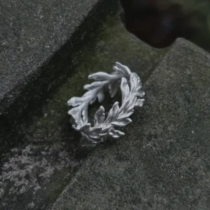 S925 Sterling Silver Poppy Leaf Ring Jewelry 08 Silver Leaf Ring Jewelry with sculpted overlapping leaf motifs displayed on a textured stone surface, highlighting its organic botanical design.