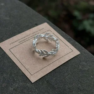 S925 Sterling Silver Poppy Leaf Ring Jewelry 09 Silver Leaf Ring Jewelry with detailed overlapping leaf motifs displayed on a brown card, highlighting its handcrafted botanical design.