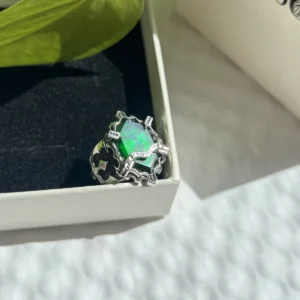 The Vongola Lightning Ring, a handmade sterling silver replica with a faceted green gemstone, displayed in a gift box.