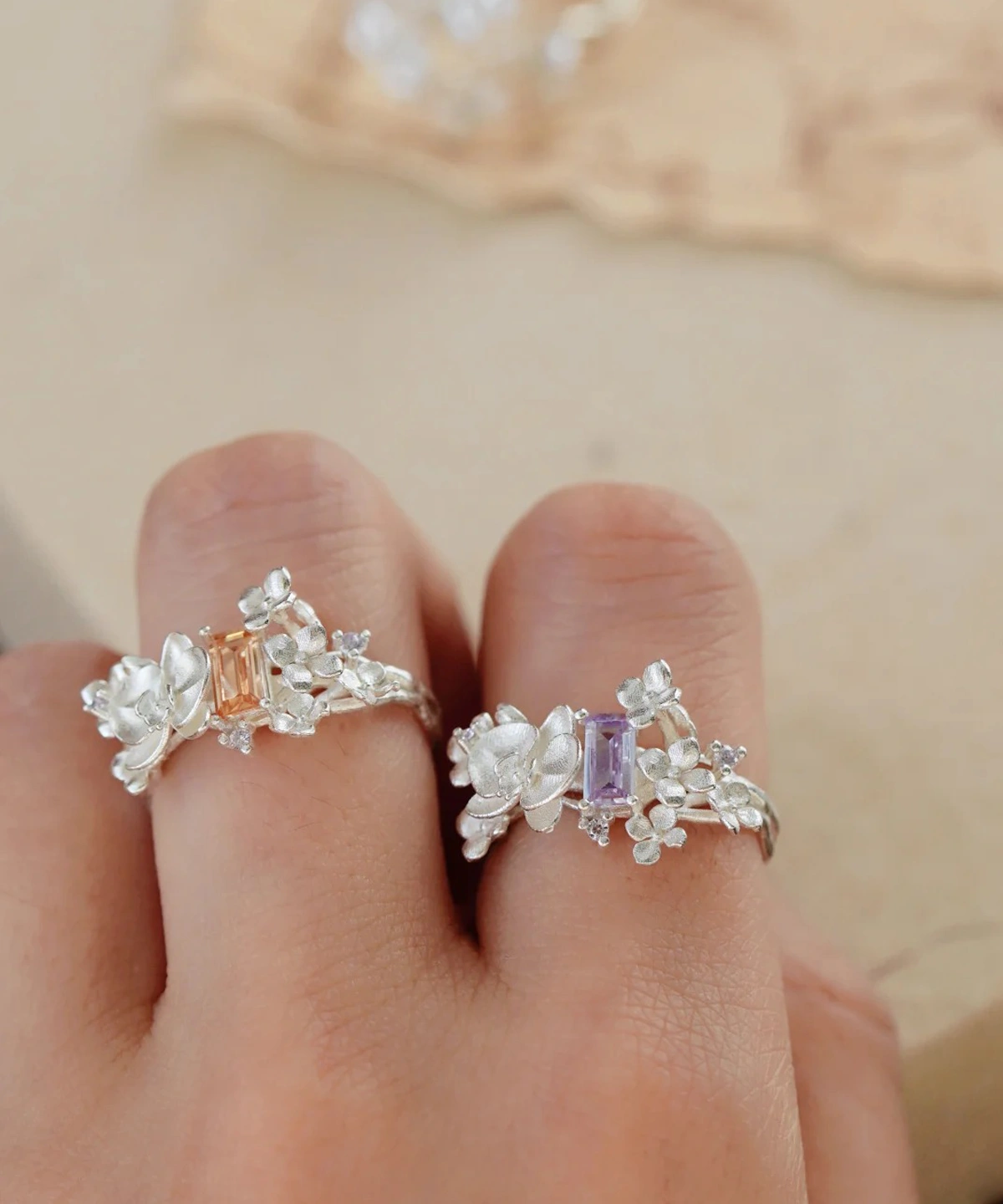 Two Unique Gemstone Ring on fingers, orchid-inspired S925 silver rings with central orange and purple rectangular gemstones.