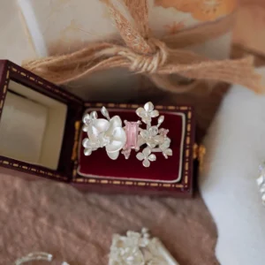 A Unique Gemstone Ring in S925 silver, orchid-inspired design with a central pink rectangular-cut gemstone, presented in a vintage-style box.