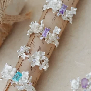 A collection of Unique Gemstone Ring in S925 silver, featuring delicate orchid-inspired floral designs with purple and blue gemstones.