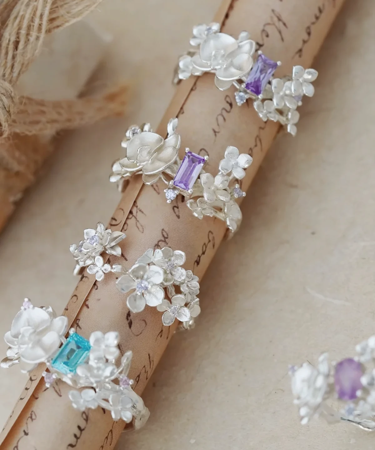 A collection of Unique Gemstone Ring in S925 silver, featuring delicate orchid-inspired floral designs with purple and blue gemstones.