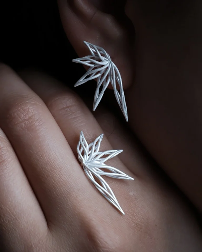 Handcrafted silver earrings with unique leaf inspired designs worn on the ear