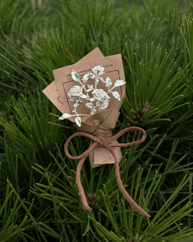 Handcrafted silver flower jewelry bouquet with detailed botanical designs