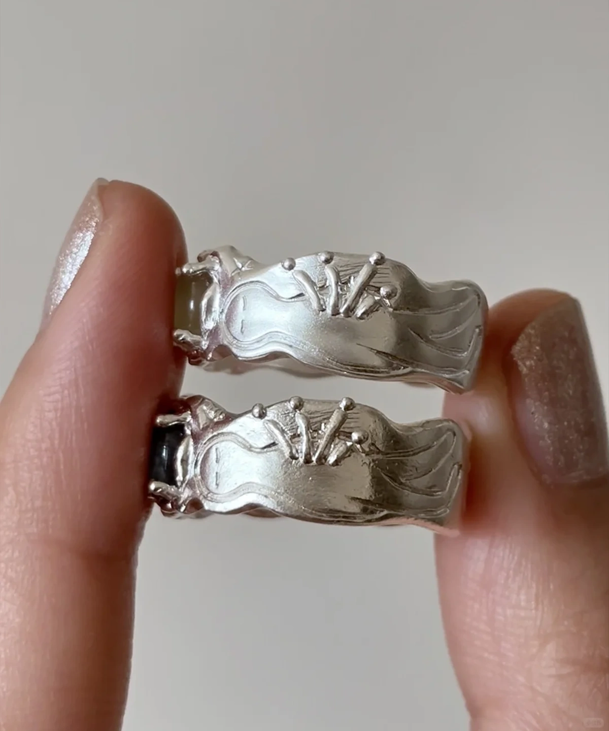 Two 999 silver rings showing carved mushroom and starburst motifs on back of band