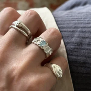 Natural aquamarine 999 silver ring with star carving worn on hand, warm light