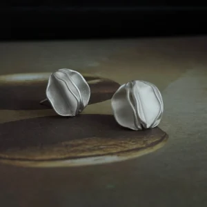 sculptural silver stud earrings on vintage metal tray, handmade jewelry lifestyle