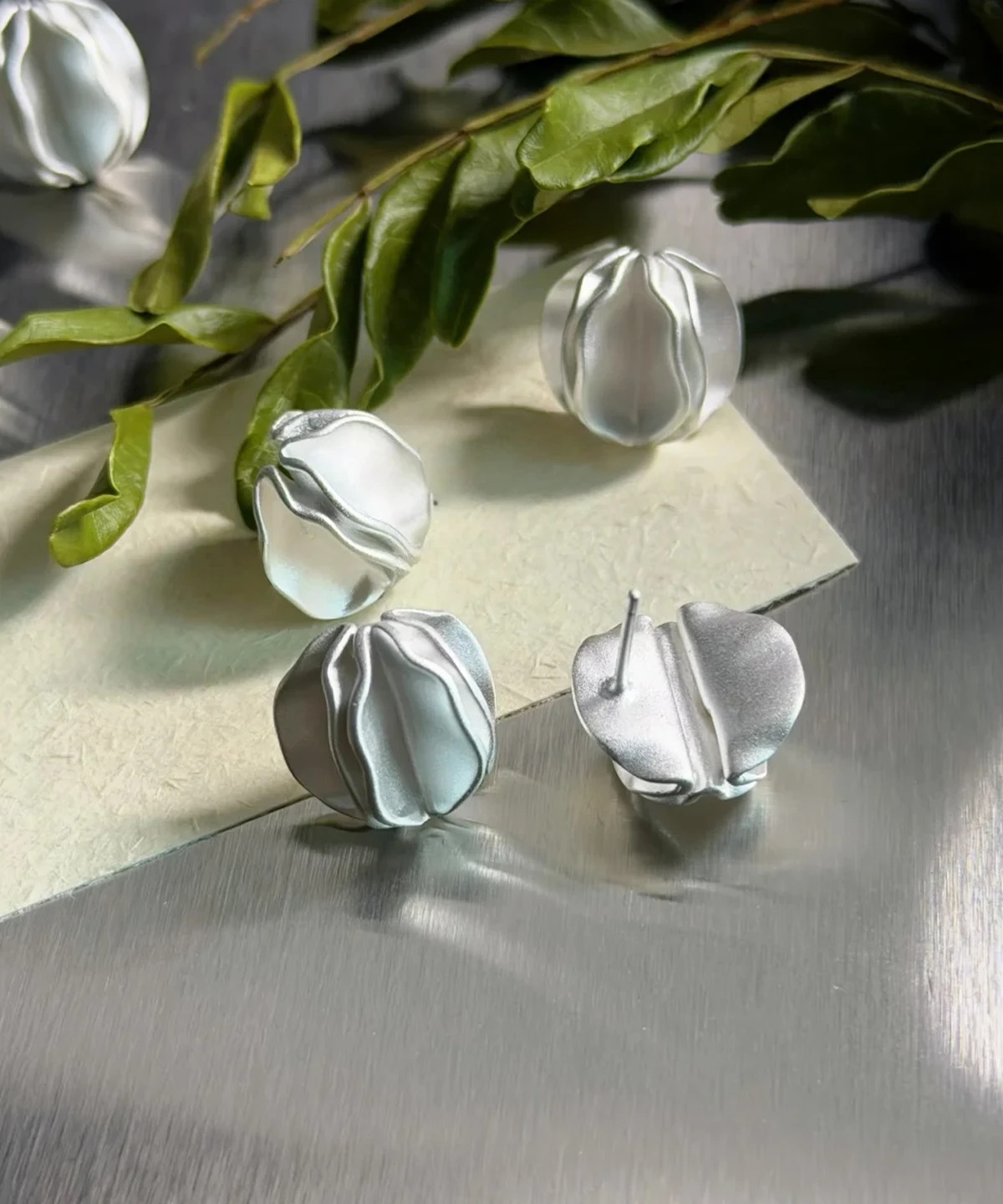 Sterling Silver Stud Earrings – Natural Light with Botanicals sterling silver stud earrings displayed with green plants, natural light