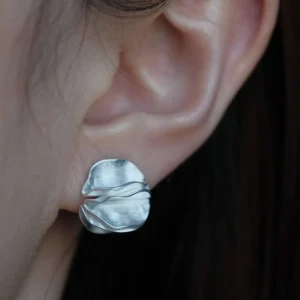 handmade sterling silver stud earrings worn on ear, sculptural round silver earring close up