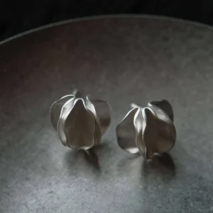 Sterling Silver Stud Earrings – Dark Background Pair Shot pair of sterling silver stud earrings on dark tray, sculptural handmade silver jewelry
