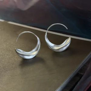 sterling silver crescent moon hoop earrings, pair front view showing full moon curve on surface