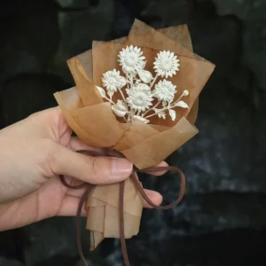 silver sunflower bouquet with multiple sterling silver stems, kraft paper wrap against dark stone