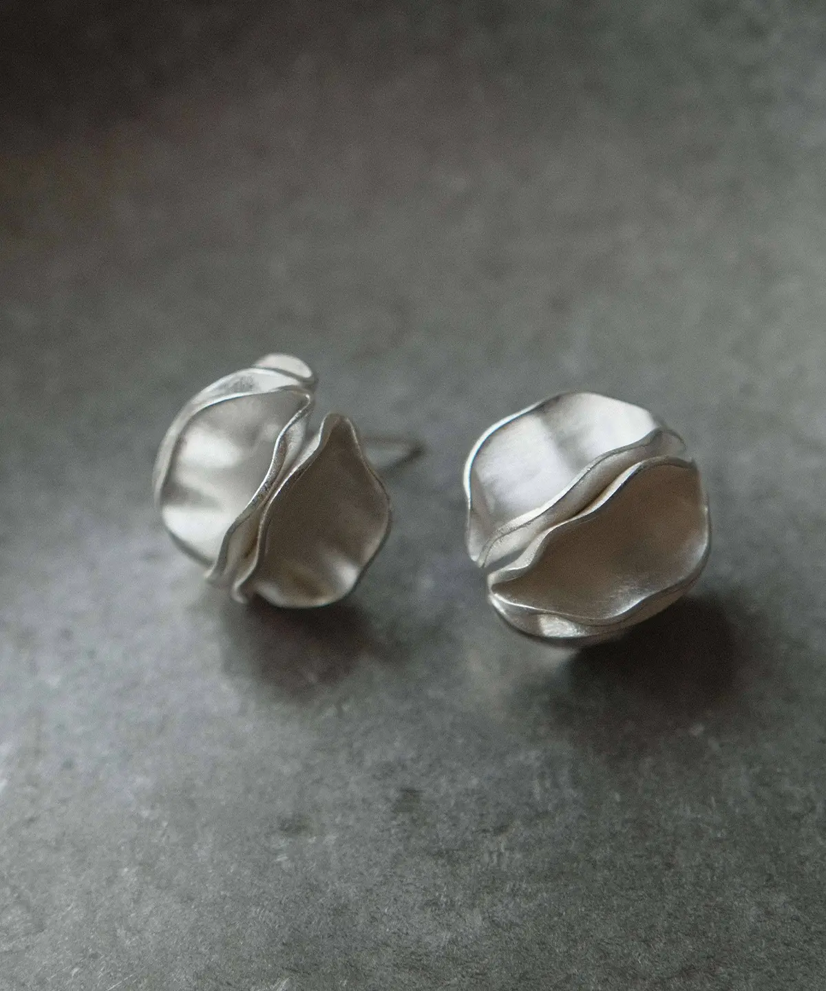 Handmade Silver Stud Earrings – Pair Product Shot pair of handmade silver stud earrings on ceramic dish, round sculptural design