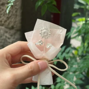polished silver sunflower wrapped in pale pink translucent paper, sterling silver flower bouquet