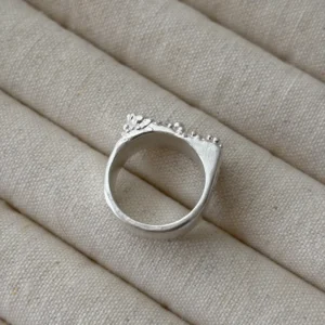 Tidemark ring back view on linen showing smooth silver band, 999 fine silver wide band ring