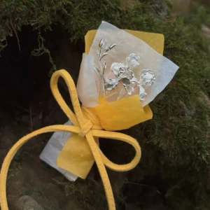 5.5 g miniature silver iris bouquet in warm wrapping displayed on wet moss