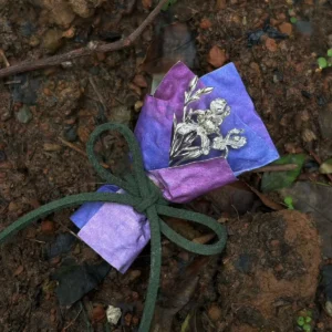 Purple wrapped 5.5 g miniature iris bouquet in 950 silver on wet woodland ground