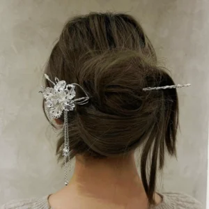 950 silver flower hair stick worn horizontally through a bun with an iris and chain drops at the side