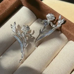 Handmade iris earrings in the Bud and Leaf style arranged as a pair in a brown jewelry box